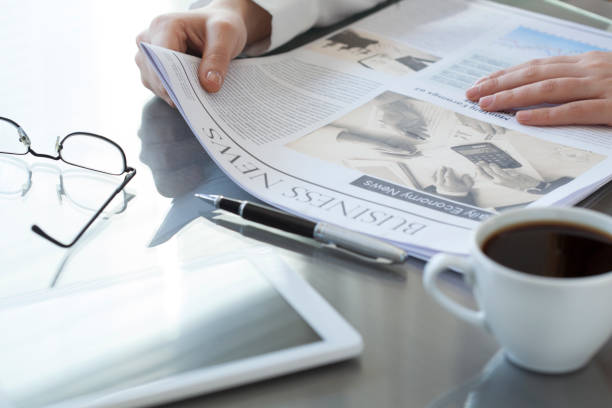 istock Woman reading newspaper on table 639442452