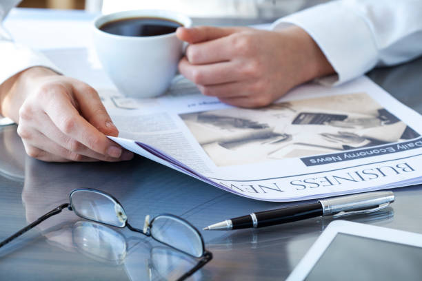 istock Businesswoman reading newspaper on worktable 639442560
