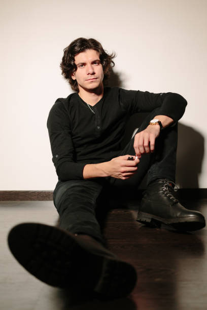 istock Man sits on the floor and leaning against the wall. 639446094