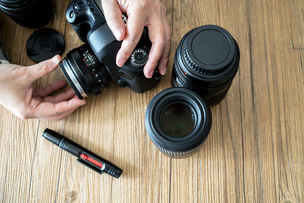 istock hand screwing lens on camera 639447334