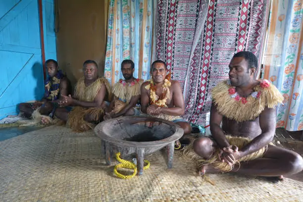 Indigenous Fijians men participate in traditional Kava Ceremony in Fiji. The consumption of the drink is a form of welcome and figures in important socio-political events.