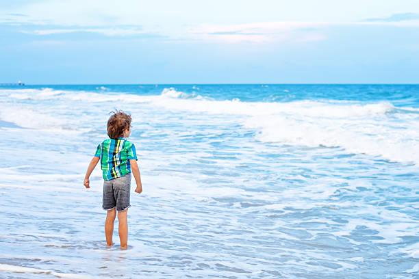 istock little kid boy looking on sunset on the beach 639448542