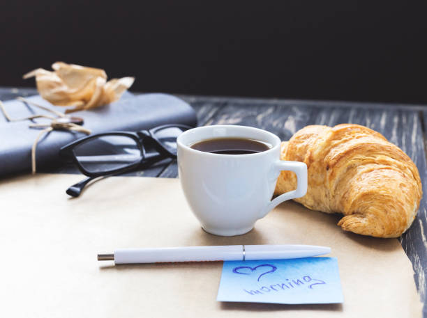 istock French croissant, glasses, coffee and notebook. Workplace concep 639450544