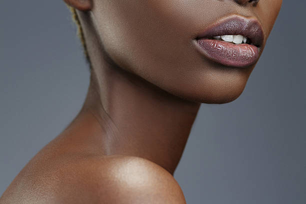 Beauty portrait   Lips  Close up  Beautiful african ethnicity  young women Lips. Close up. Beauty, fashion portrait. Original looks. Beautiful, lovely  and sensual young african girl.  Attractive African ethnicity,  slim women. Gray wall background. thin neck stock pictures, royalty-free photos & images