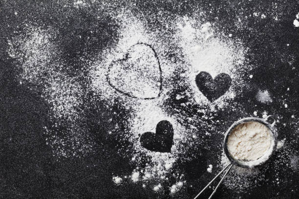 Baking background with heart shape from flour. Flat lay. Vintage. stock photo
