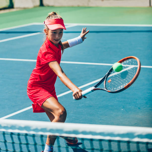 teenage girl playing tennis - tennis serving playing women imagens e fotografias de stock