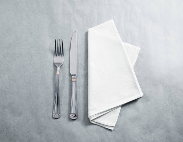 Blank white restaurant napkin mockup with knife and fork Blank white restaurant napkin mockup with knife and fork, isolated. Cutlery near clear textile towel mock up template. Cafe brand identity overlay surface for logo design. napkin stock pictures, royalty-free photos & images