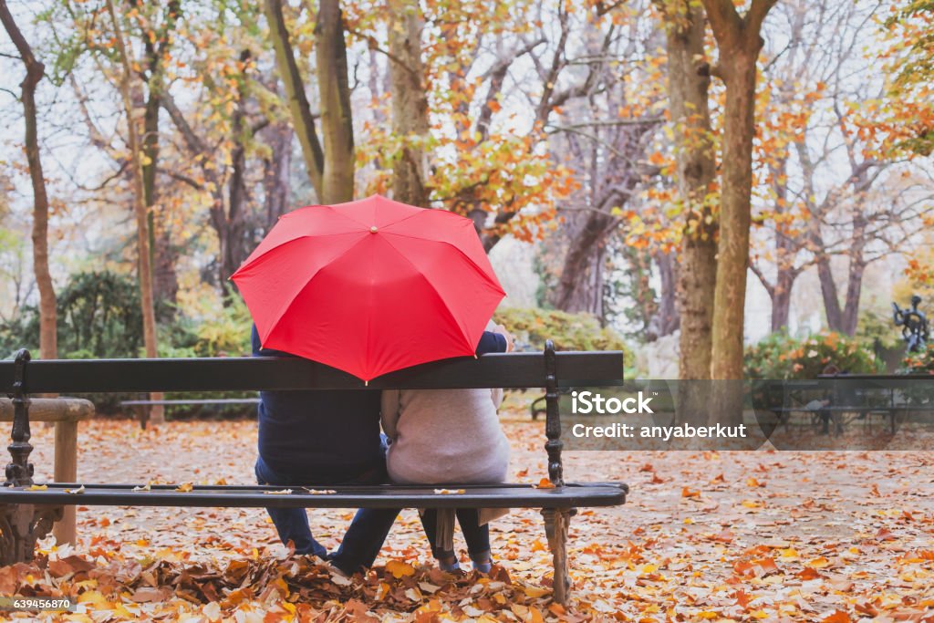 casal aposentado idoso sentados juntos sob guarda-chuva - Foto de stock de Novembro royalty-free