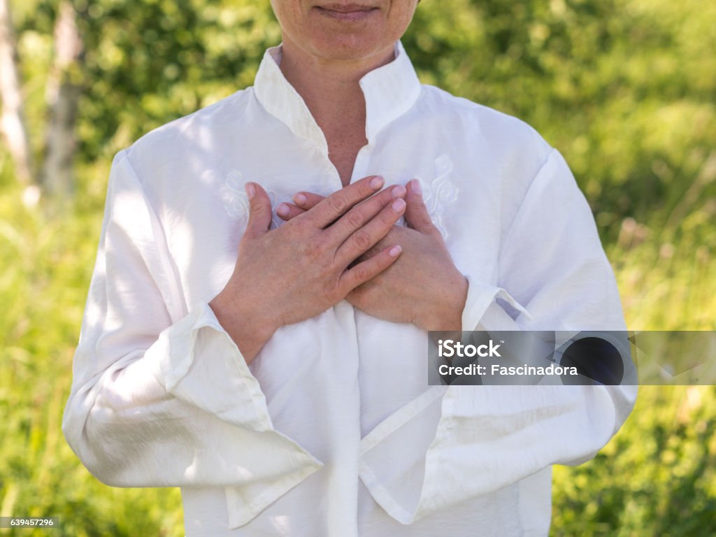 Relaxing Heart Women's hands on heart in meditating Hand On Heart Stock Photo