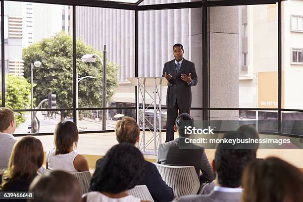 Black Businessman Presenting Seminar Gesturing To Audience Stock Photo - Download Image Now