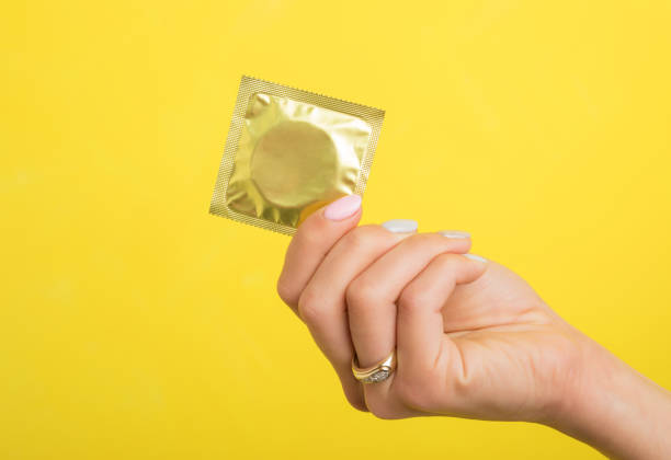 のコンドームを持つ女性 - condom contraceptive sensuality healthcare and medicine ストックフォトと画像