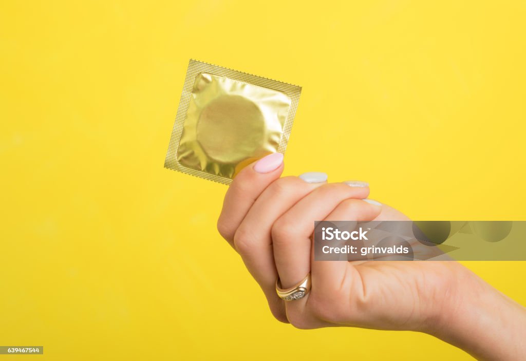 Woman holding a condom Condom Stock Photo
