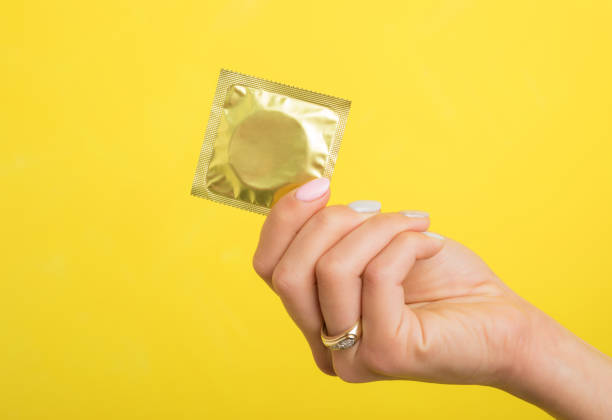 Woman holding a condom stock photo