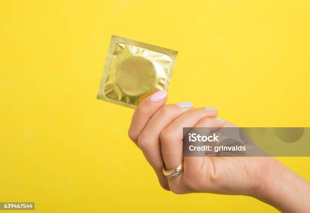 Woman Holding A Condom Stock Photo - Download Image Now - Condom, Women, Sex Education