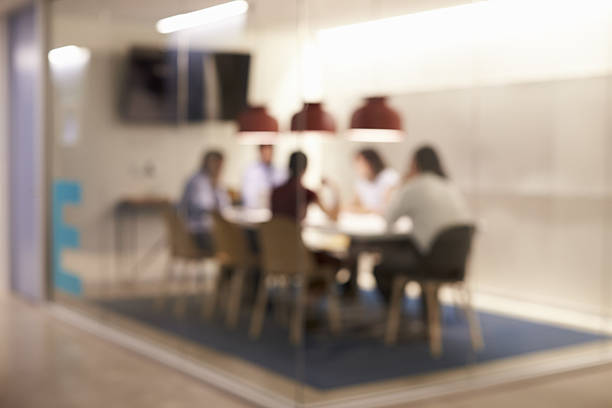 корпоративная деловая команда за столом в зале заседаний - low key стоковые фото и изображения