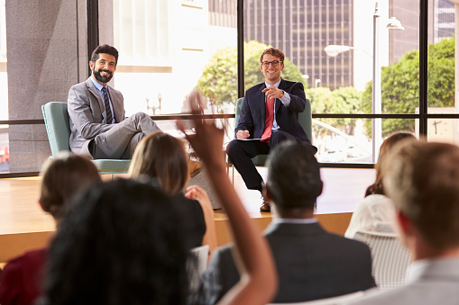 An African man giving a speech at a business technology conference.