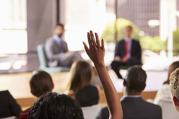 ビジネスセミナーで質問を求める聴衆を配る - hand raised asking women businesswoman ストックフォトと画像