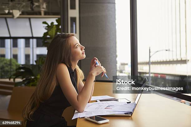 Businesswoman Working In An Office Looking Out Of The Window Stock Photo - Download Image Now