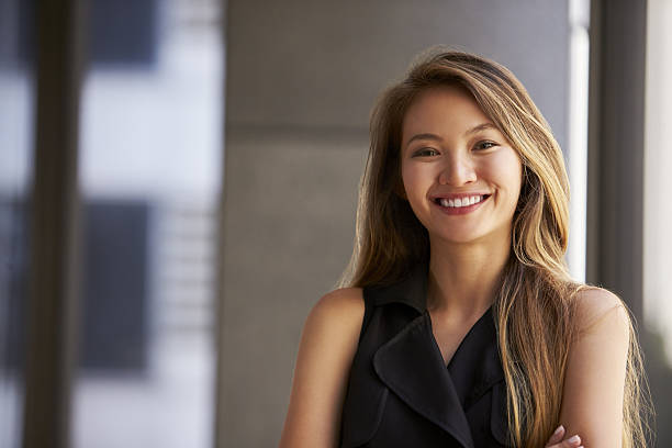 Young Asian businesswoman smiling to camera, close up Young Asian businesswoman smiling to camera, close up redhead photos stock pictures, royalty-free photos & images