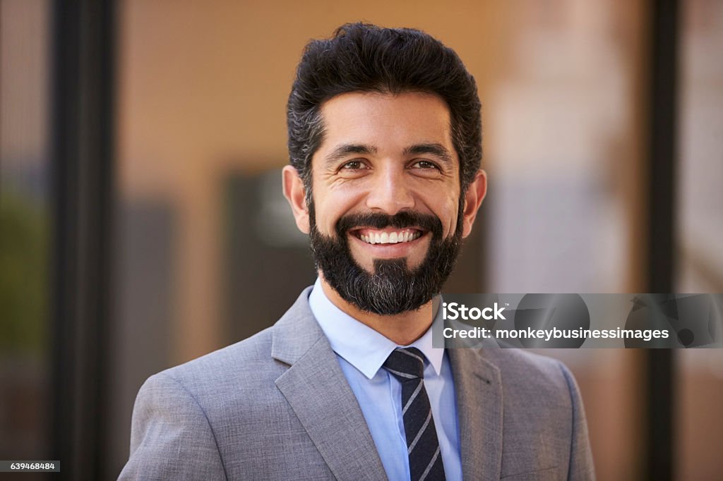 Happy middle aged Hispanic businessman looking to camera Headshot Stock Photo