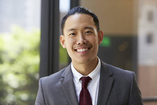 istock Young Asian businessman looking to camera, close up 639468546