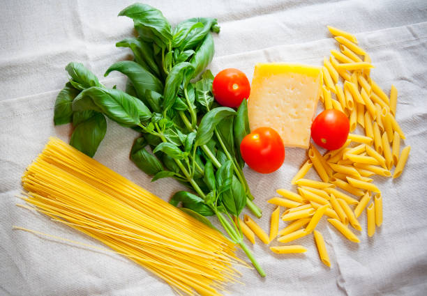 istock Basil, tomatoes, parmesan, cappellini and penne on gray tablecloth 639470082