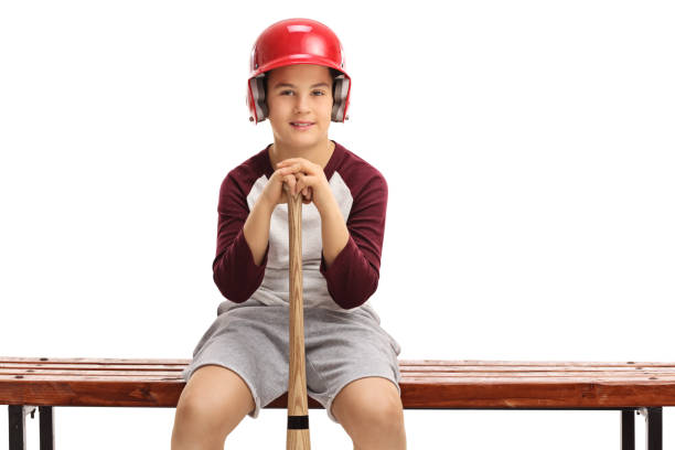 istock Boy with helmet and baseball bat sitting on bench 639470580