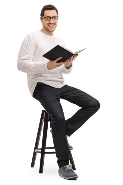 istock Joyful guy with a book sitting on a chair 639471030