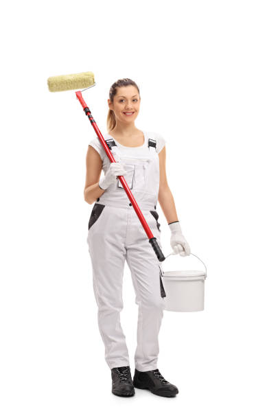 istock Happy female painter holding paint roller and color bucket 639471280