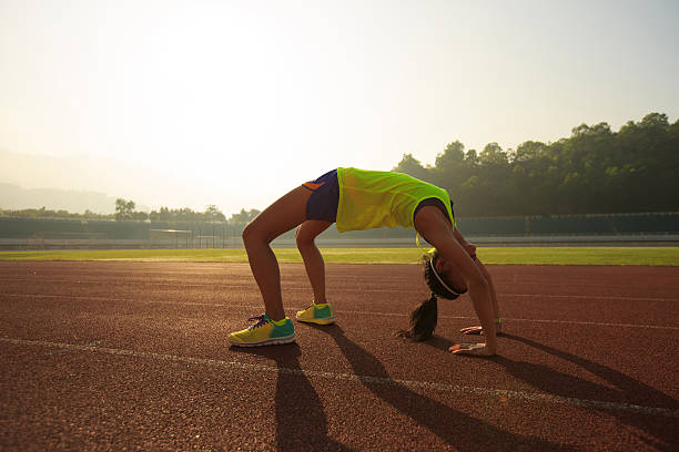 istock young asian woman backbending on stadium track 639471318