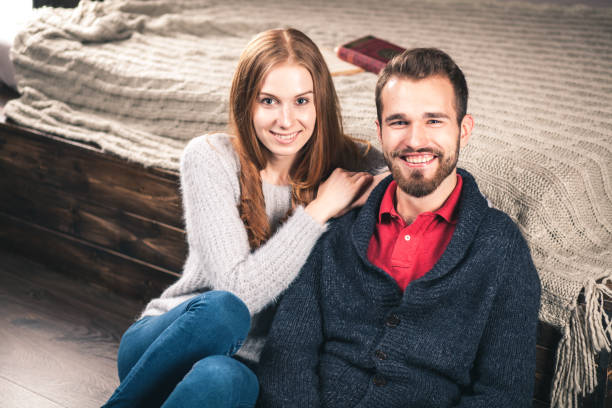 若いカップルの自宅で - brick red wool heat ストックフォトと画像