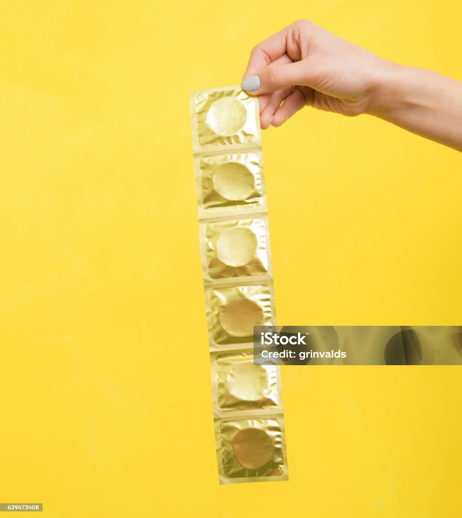 Woman holding condoms Human Hand Stock Photo