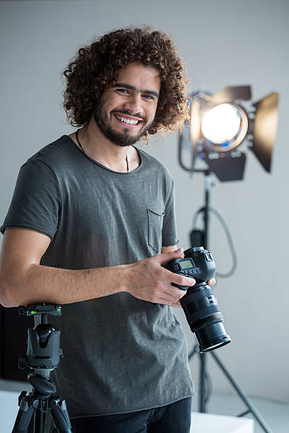 istock Happy male photographer standing in studio 639473598