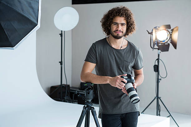 istock Happy male photographer standing in studio 639473762