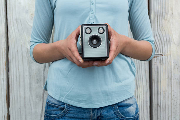 środkowa część fotografki trzymającej staromodny aparat - camera retro revival old fashioned holding zdjęcia i obrazy z banku zdjęć