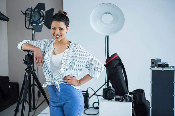 istock Happy female photographer standing in studio 639474104
