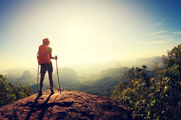 young woman backpacker hiking at seaside mountain cliff