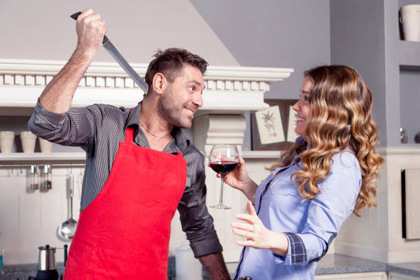 jeune mari plaisante avec sa femme dans la cuisine - attractive female indoors lifestyles clean photos et images de collection