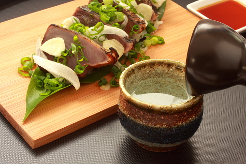 Seared bonito with Japanese sake, sliced onions, chopped leeks and sliced garlic