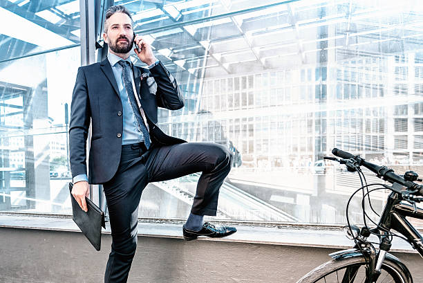 istock handsome bearded business man with bicycle using mobile in city 639484474