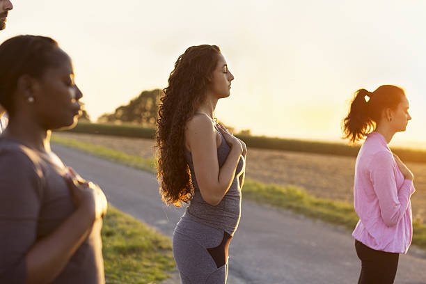 istock small women group exercising Yoga outdoors at sunset 639487040