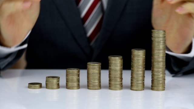 Businessman Protecting Coins Stack On Desk