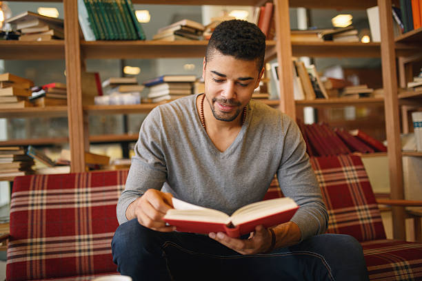 istock Smiling African American student enjoying book reading in library 639492746