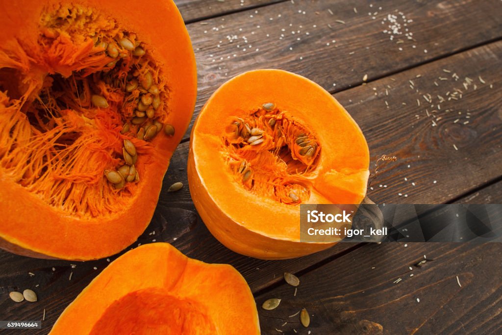 Several cut pumpkins on wood closeup Several cut pumpkins on wood closeup. Fresh orange squashes on wooden table, country autumn background. Seasonal, harvest, fall concept Slice of Food Stock Photo