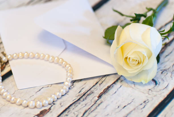 istock beautiful white rose string of pearls and letter envelope love 639496776