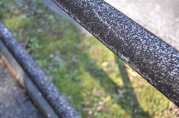 Rusty handrail Detail of and old and rusty handrail. Grass on the background. baseball rundown stock pictures, royalty-free photos & images