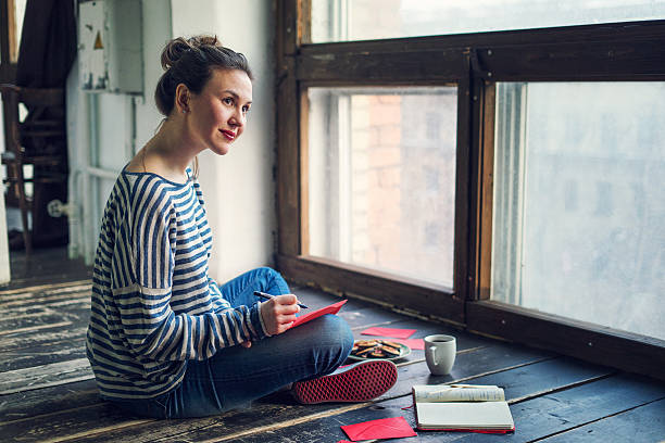 young woman writing a valentine card - writing letter correspondence women imagens e fotografias de stock