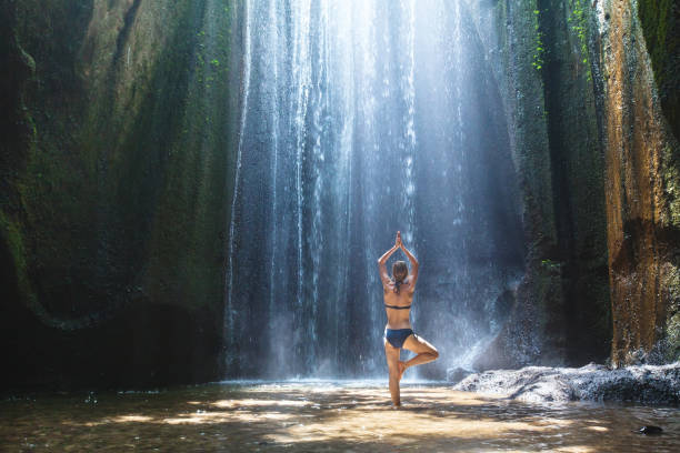 yoga, beautiful woman practices in waterfall, body and mind harmony - waterfall health spa man made landscape imagens e fotografias de stock