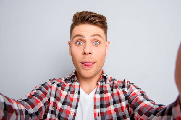 istock Handsome comic man showing tongue and making selfie 639511604