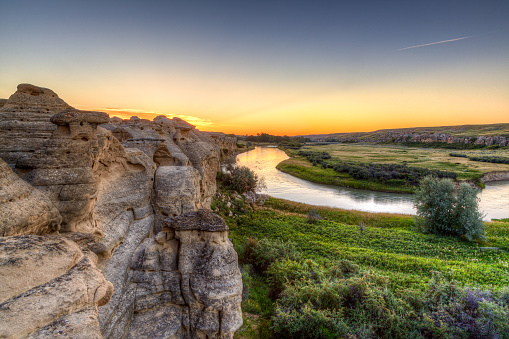 Golden sunrise over the Hoodoo badlands at Writing-on-Stone Provincial Park in Alberta, Canada. The area contains the largest concentration of First Nation petroglyphs (rock carvings) and pictographs (rock paintings) on the great plains of North America.